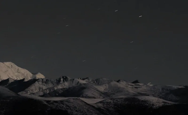 A snowy ridge fading into the dark
